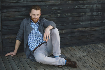 Handsome young man sitting on the wooden floor