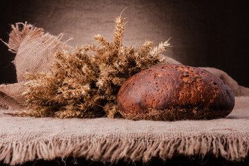 Loaf of bread and rye ears still life