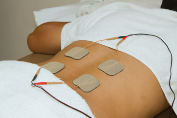 Patient  applying electrical stimulation therapy ( TENS ) on his