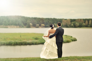 Fototapeta premium Wedding couple standing near a lake