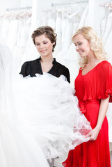 Naklejka premium Two girls stare at the wedding dress