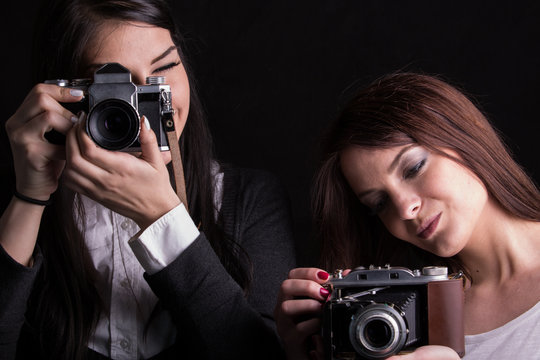 Beautiful women making photos with old vintage analog cameras