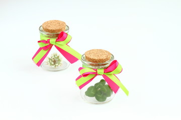 Four leaf clover and flowers  in a glass with colorful ribbon