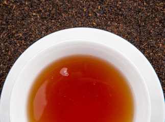 A cup of tea on dried and processed tea leaves