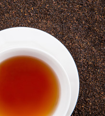 A cup of tea on dried and processed tea leaves