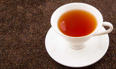 A cup of tea on dried and processed tea leaves