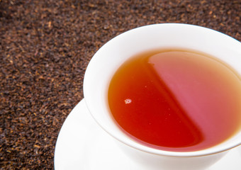 A cup of tea on dried and processed tea leaves