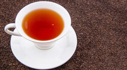 A cup of tea on dried and processed tea leaves