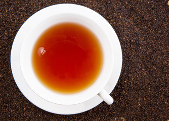A cup of tea on dried and processed tea leaves