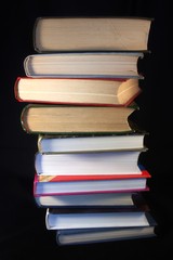 Pile of old and new books on a black background