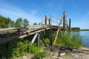 Obsolete bridge on the shore of a lake