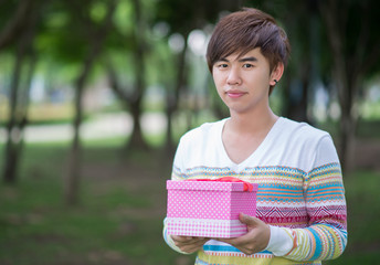 Male is holding a pink gift box