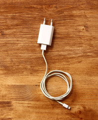 white smartphone charger over wooden board 