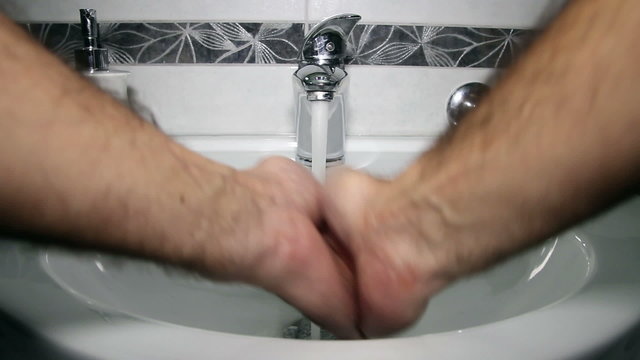 Man Washing Hands in Bathroom