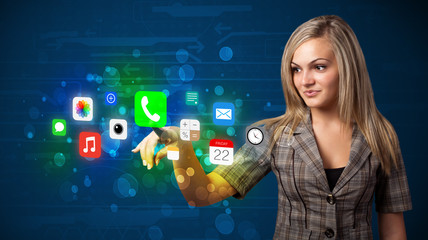 Young businesswoman pressing colorful mobile app icons with boke