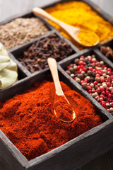 spices in box: pink  black pepper, paprika powder, curry, bay le