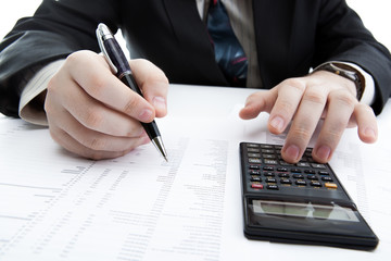 businessman holding a pen and counts the budget