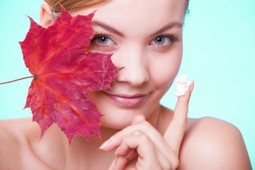 Naklejka na ściany i meble Skin care. Face of young woman girl with red maple leaf.