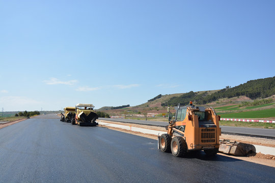 carretera con asfalto reciente y maquinaria de construccion