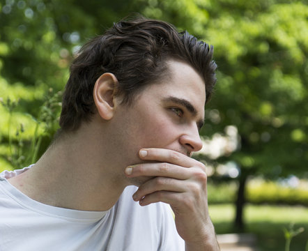 Unhappy, Sad Young Man Outdoors In Park Thinking