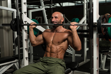 Fototapeta na wymiar Bodybuilder Doing Heavy Weight Exercise For Shoulder