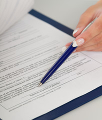 businesswoman giving you the pen and the contract to sig