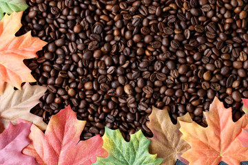 Kaffeebohnen mit bunten Herbstblättern umrandet