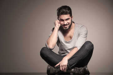 pensive young man with beard smiling