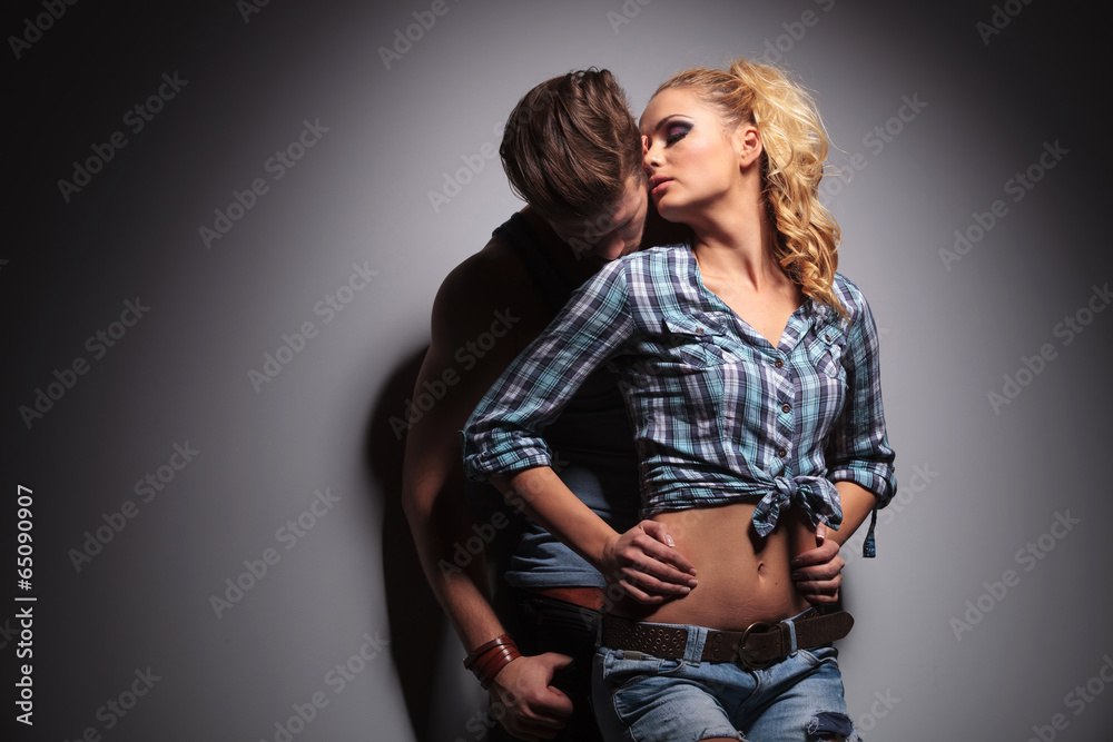 Wall mural passionate casual young couple standing embraced