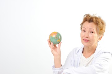 地球儀を持つシニアのアジア人女性