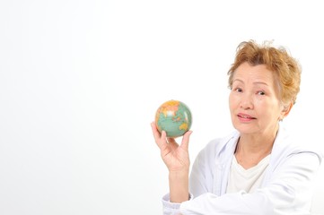 地球儀を持つシニアのアジア人女性