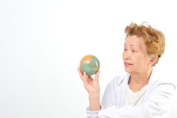 地球儀を持つシニアのアジア人女性