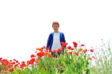 お花畑を歩く高齢の女性