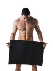 Naked young male bodybuilder holding blank board