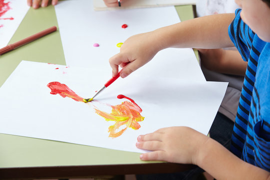 Hand vom Kind mit Pinsel und Farbe