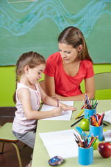 Mädchen lernt schreiben im Kindergarten