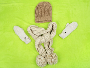 Winter cap, scarf and mittens, on color background