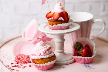 Tasty cup cakes with cream on wooden chair