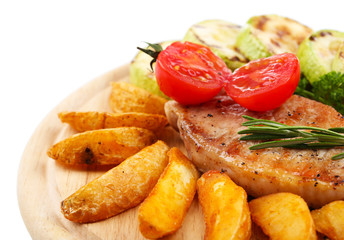Grilled steak with fried potato pieces and grilled vegetables