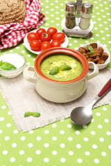 Tasty soup in saucepan on tablecloth, close up
