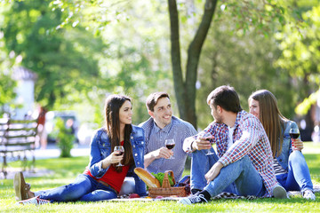 Happy friends on picnic in park