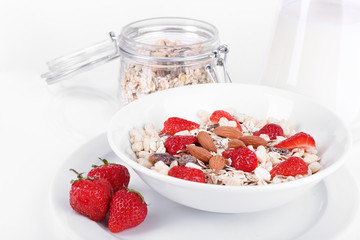 Healthy cereal in bowl with milk and strawberries isolated