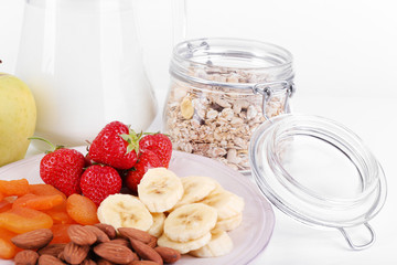 Healthy cereal with milk and fruits close up