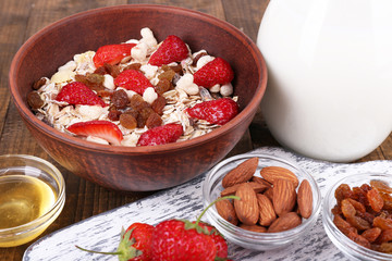 Healthy cereal with milk and strawberry on wooden table