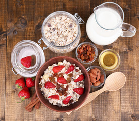Healthy cereal with milk and strawberry on wooden table