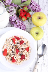 Healthy cereal with milk and fruits on wooden table