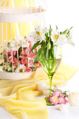 Freesias in glass on table on fabric background