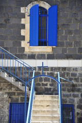 Entrance to the ancient house with blue windows, doors and handrails