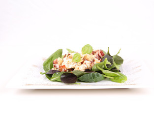 Scrambled eggs with ham on spinach