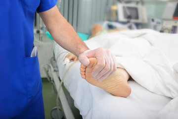 Obraz na płótnie Canvas Badanie lekarskie pacjenta. Lekarz dotyka on nogę